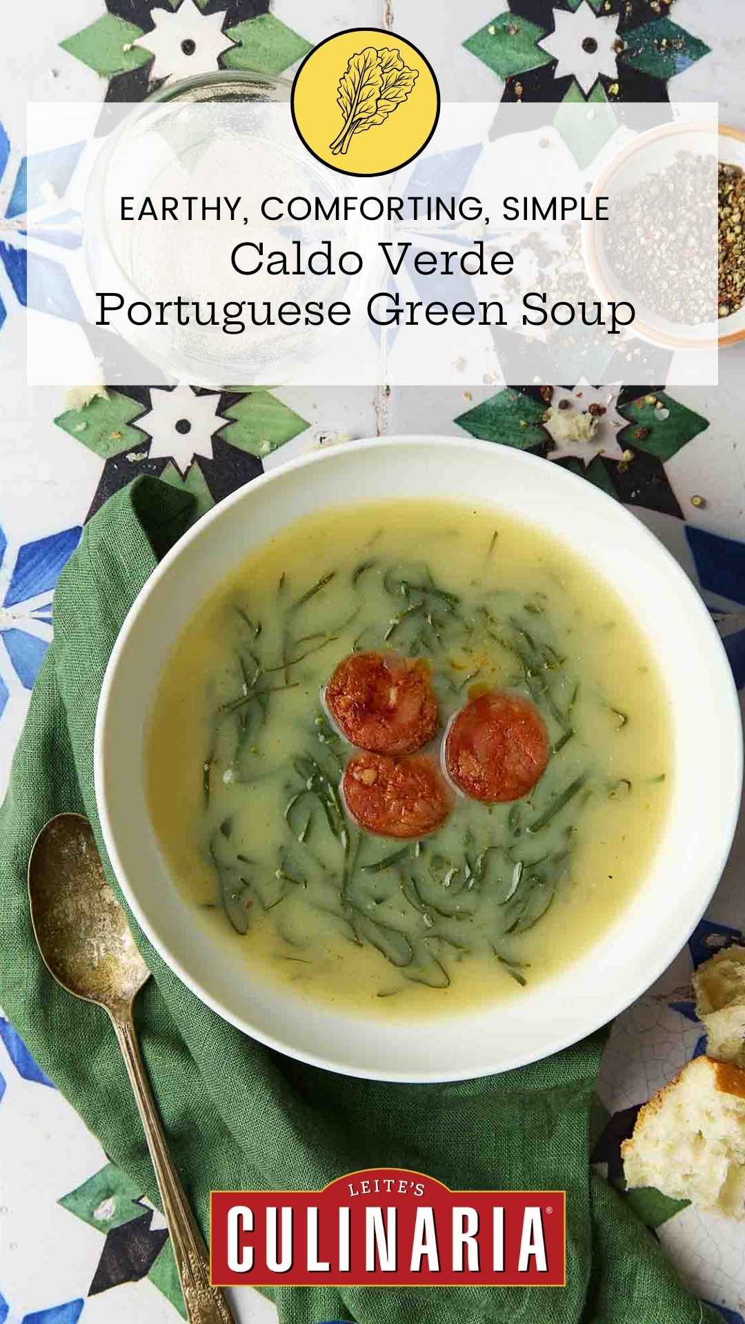 A white bowl of caldo verde, or Portuguese kale soup (green broth) with thinly sliced kale and three chourico coins floating in the center.