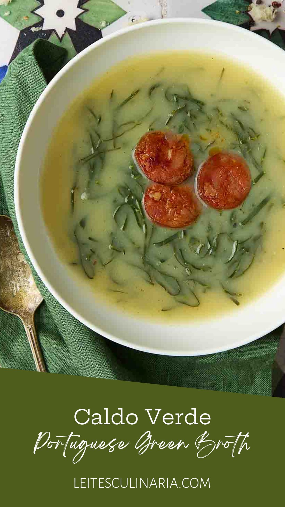 A white bowl of caldo verde, or Portuguese kale soup (green broth) with thinly sliced kale and three chourico coins floating in the center.