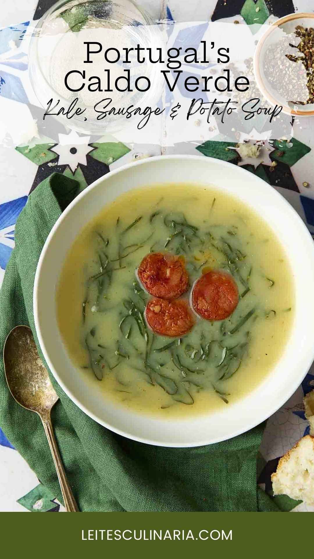 A white bowl of caldo verde, or Portuguese kale soup (green broth) with thinly sliced kale and three chourico coins floating in the center.