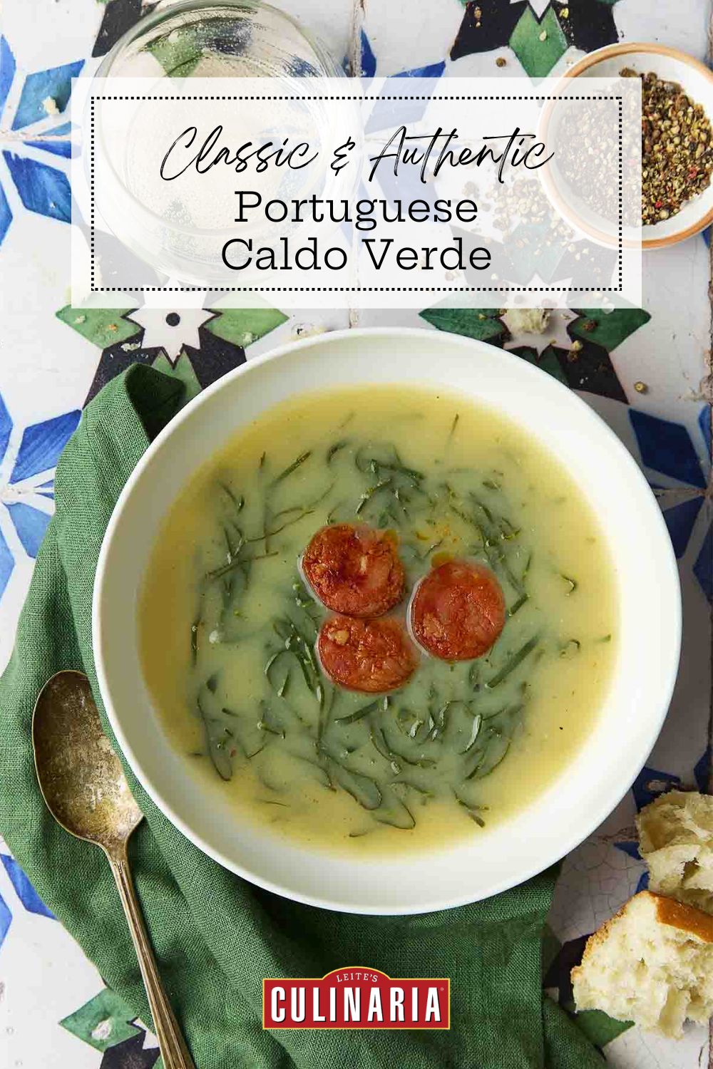 Traditional Portuguese green soup with kale and sausage served in a white bowl on a colorful tiled table.