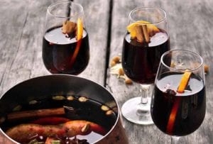 Three glasses of glogg (mulled wine) with orange slices and cinnamon sticks