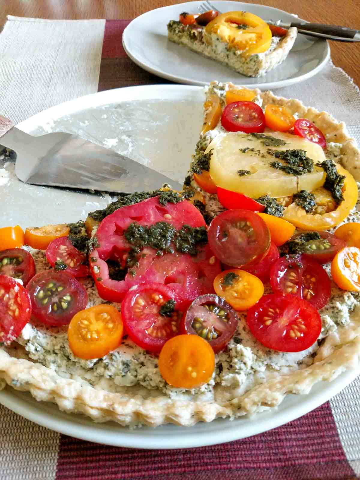 A fresh tomato tart in a herbed crust, drizzled with pesto vinaigrette.