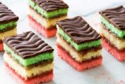 Six Italian rainbow cookies on a marble slab