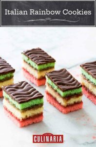Six Italian rainbow cookies on a marble slab