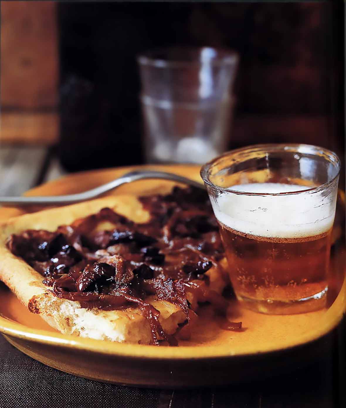 Pissaladière square on a plate with beer.