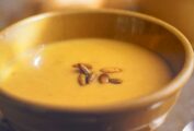 A bowl of pumpkin soup with curried pumpkin seeds on top
