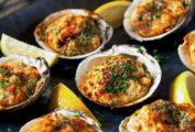 6 baked clams on a black platter