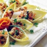 Endive leaves stuffed with cream cheese spread with smoked salmon with chopped chives on top.