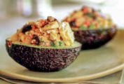Two avocado halves filled with fresh tuna with dry-cured black olives.