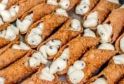 Sheet pan of 2 dozen cannoli filled with sweet ricotta filling and chocolate chips