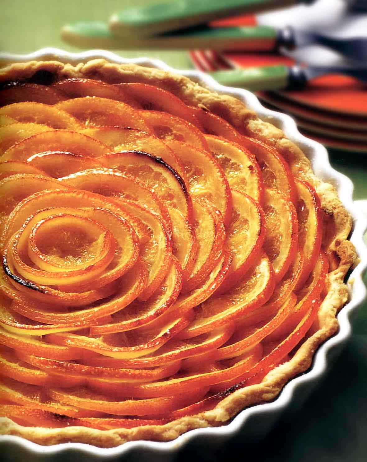 A Valencian orange tart with slices of oranges in a circular pattern in a pastry crust