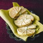 12 Key lime sugar cookies in the shape of lime wedges with lime icing
