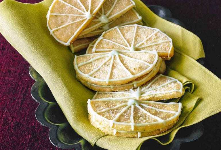 12 Key lime sugar cookies in the shape of lime wedges with lime icing