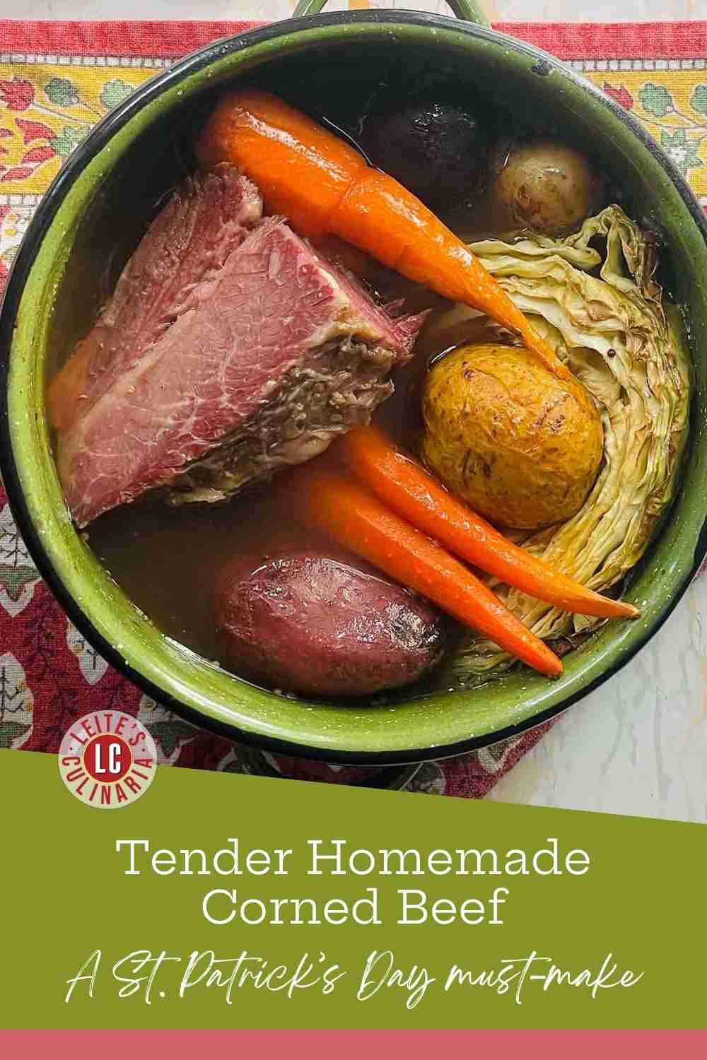 Slices of pink corned beef in a green pot with whole carrots, potatoes, and cabbage in a savory broth.