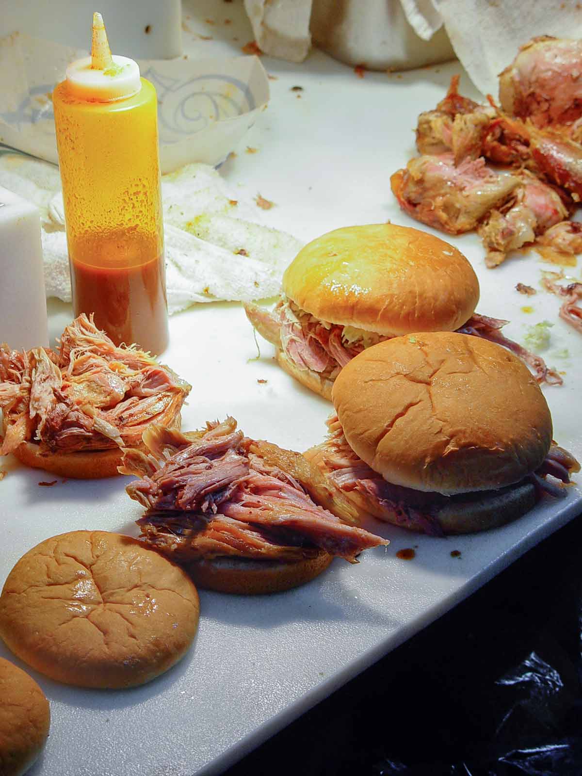 Four pull pork sandwiches and vinegar barbecue sauce