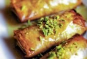 Four phyllo pastries stuffed with nuts, honey, and orange blossom water, and topped with pistachios and more honey.