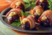 Plate of crispy bacon-wrapped stuffed dates held by toothpicks, parsley garnish