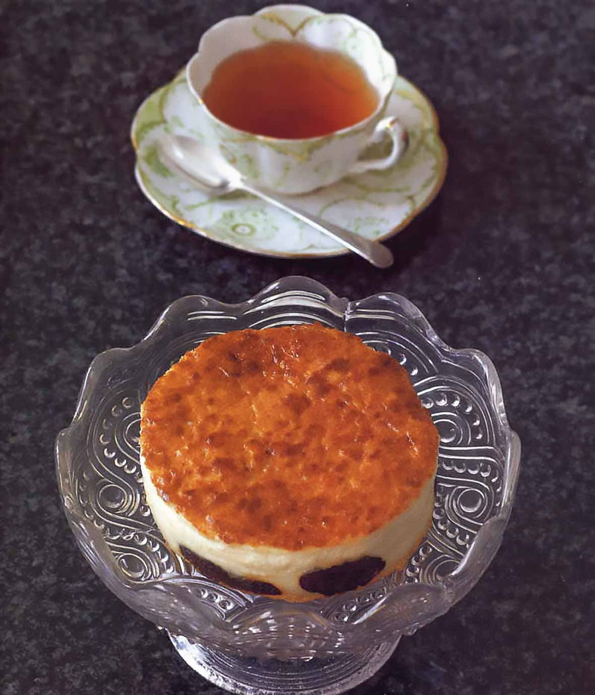 Far Breton French Custard Cake on cake stand with a cup of tea.