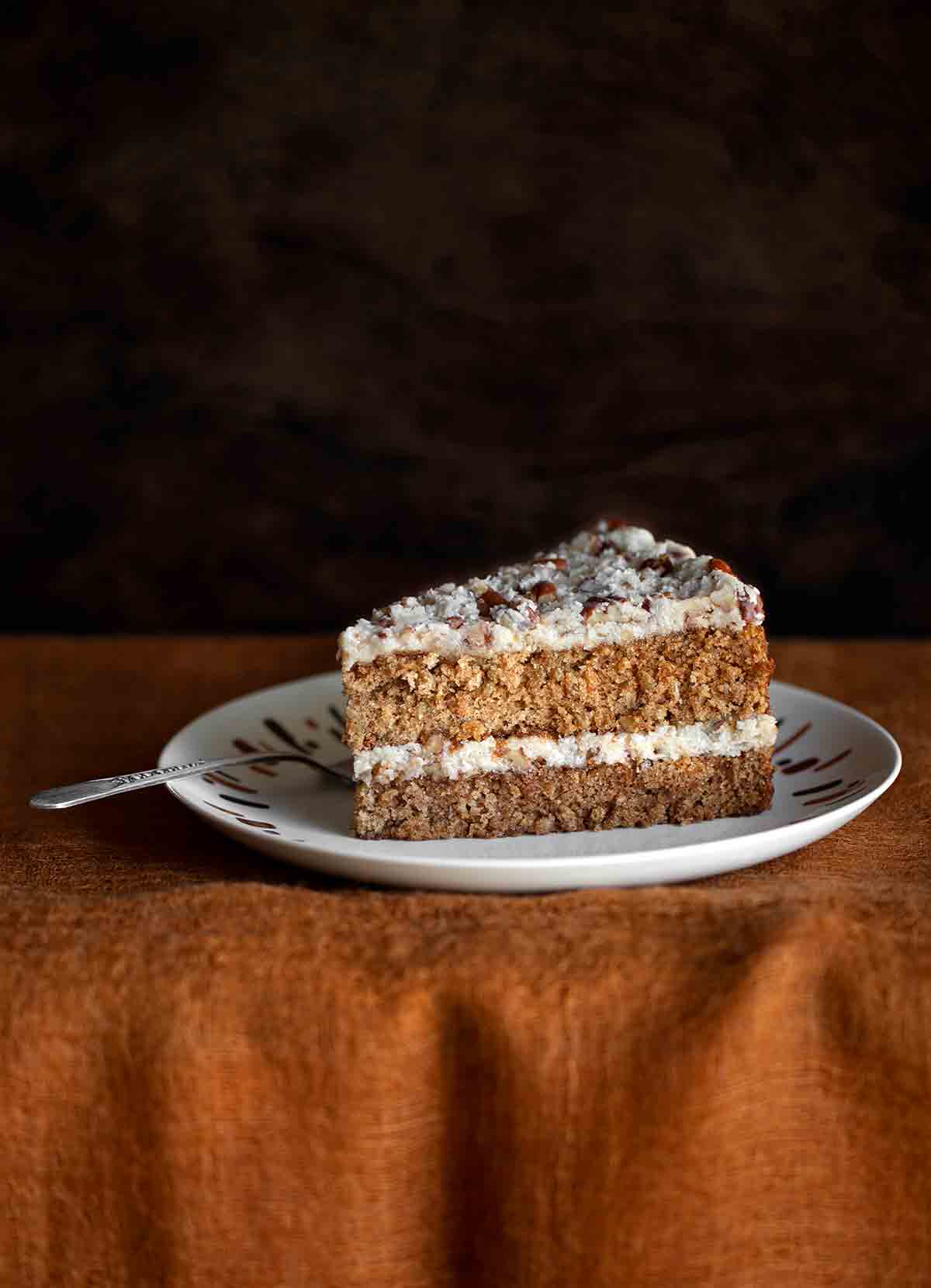 A slice of oatmeal cake on a plate with a fork