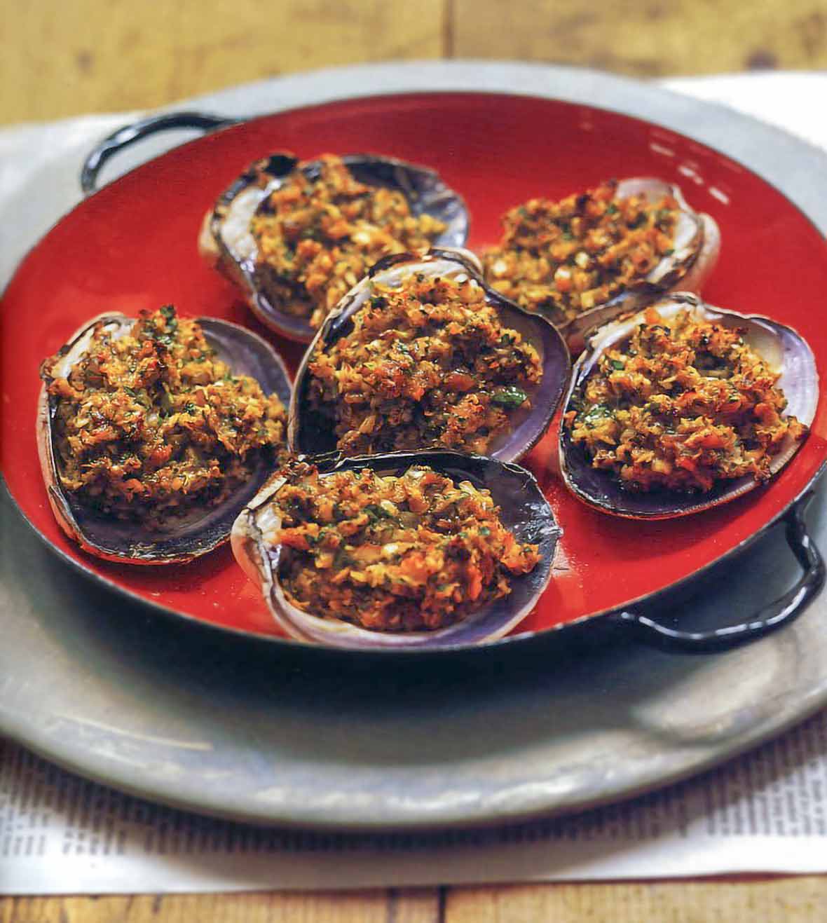 Red plate of six stuffed quahogs clams stuffed with breadcrumbs, chopped clams, parsley, Old Bay Seasoning