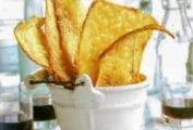 White bucket filled with rustic golden brown Parmesan flatbreads on a plaid napkin