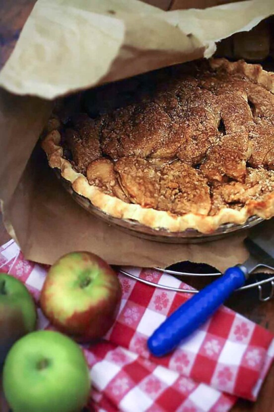 A cooked brown-bag apple pie inside a torn paper bag