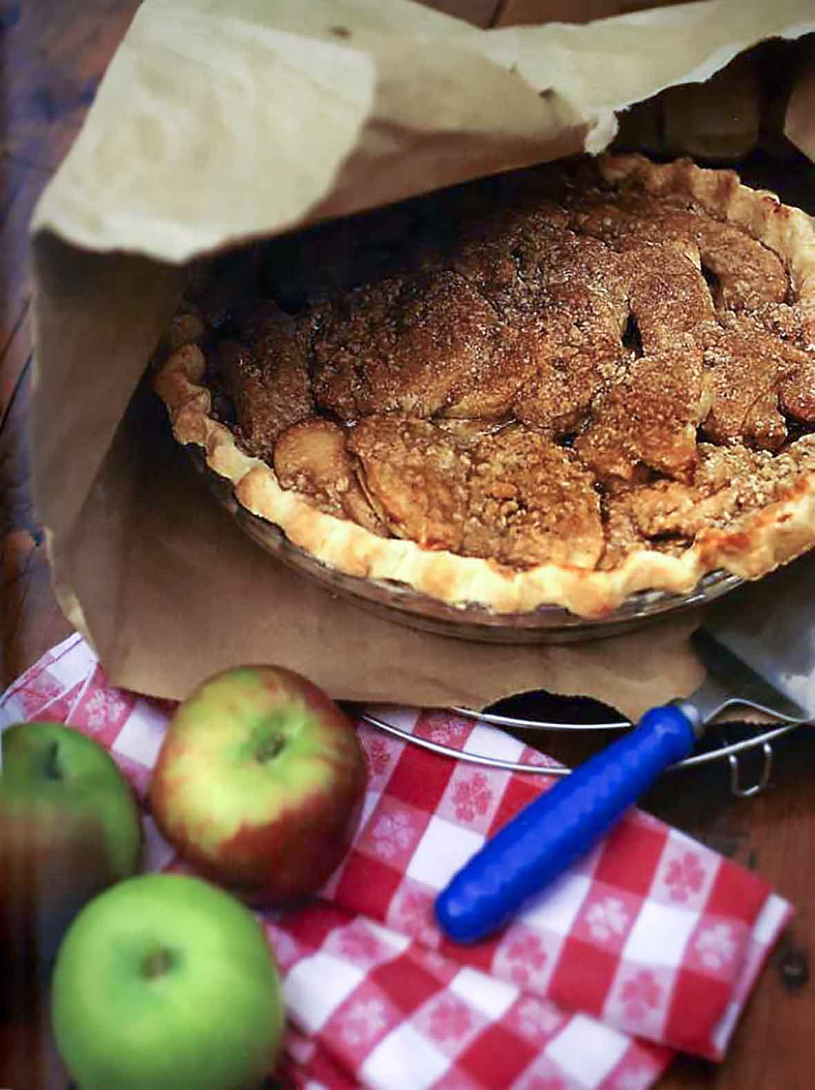 A cooked brown-bag apple pie inside a torn paper bag