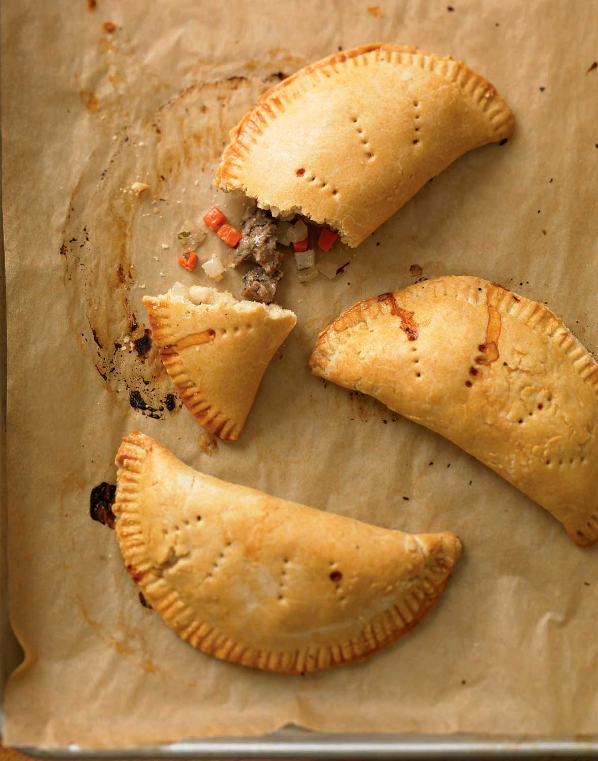 Three cornish pasties on a sheet of parchment