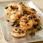 Shrimp with black beans piled on a rectangular metal tray.