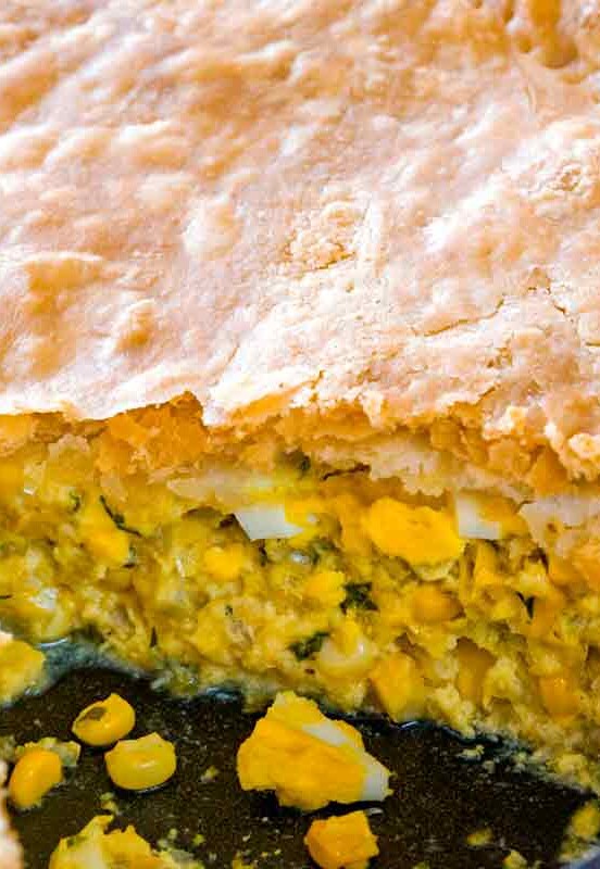 A corn pie, with a sliced remove, the filling of corn, egg, celery, onion, parsley can be seen