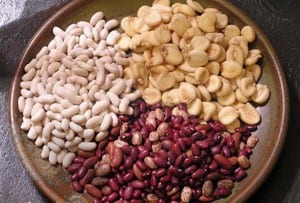 A trio of the beans used in manchup, in a wooden bowl on a stone counter