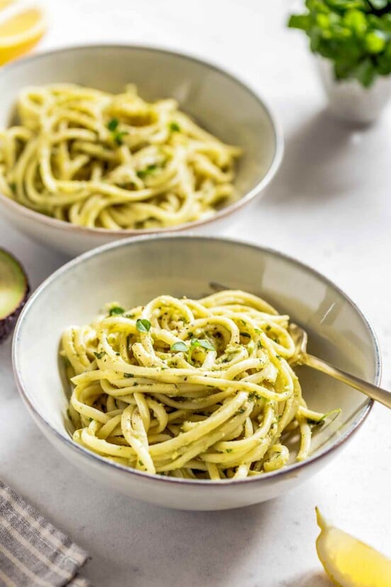 Two bowls of angel hair pasta with lemon cream sauce.