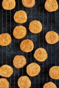 Cheddar-Parmesan crackers on a black wire rack.