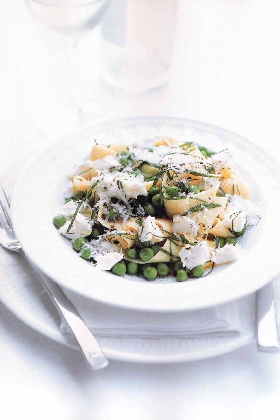 A white bowl filled with lemon, ricotta, and pea pasta.