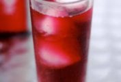 Tall glass of tinto de verano, a read wine with Sprite, and ice cubes.