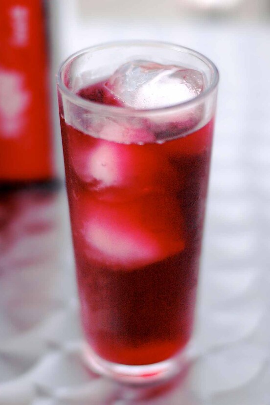 Tall glass of tinto de verano, a read wine with Sprite, and ice cubes.