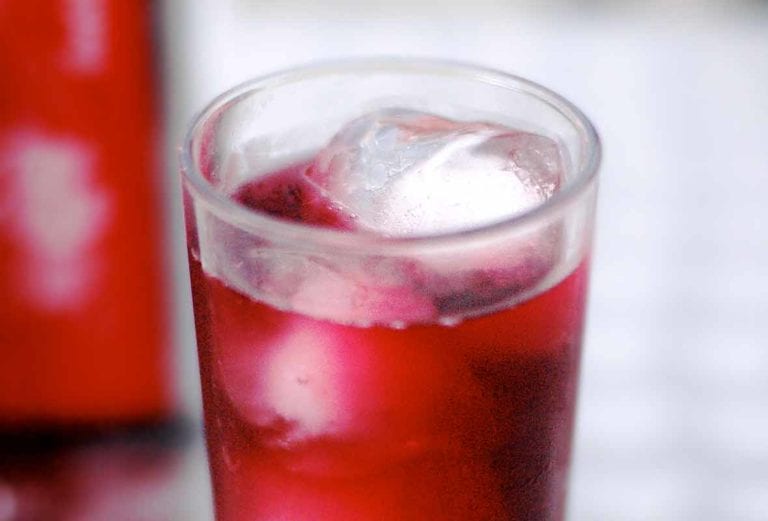 Tall glass of tinto de verano, a read wine with Sprite, and ice cubes