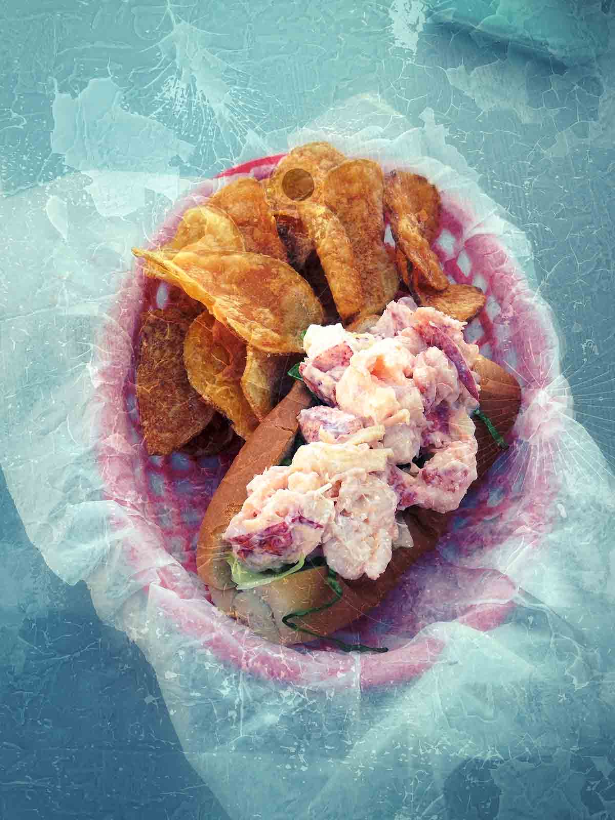 A lobster roll with mayonnaise and chips in a pink basket