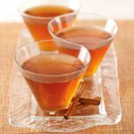 Three glasses of Maple Leaf Cocktails on a glass tray with cinnamon sticks