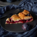 Close-up of a single slice of Marian Burros' plum torte, showing the jammy fruit filling.