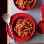 A red bowl with Christmas Eve calamari--calamari, onion, garlic, red pepper flakes in a tomato sauce