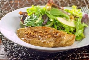 Cinnamon crunch chicken breast with a topping made from speculoos cookies, a salad behind