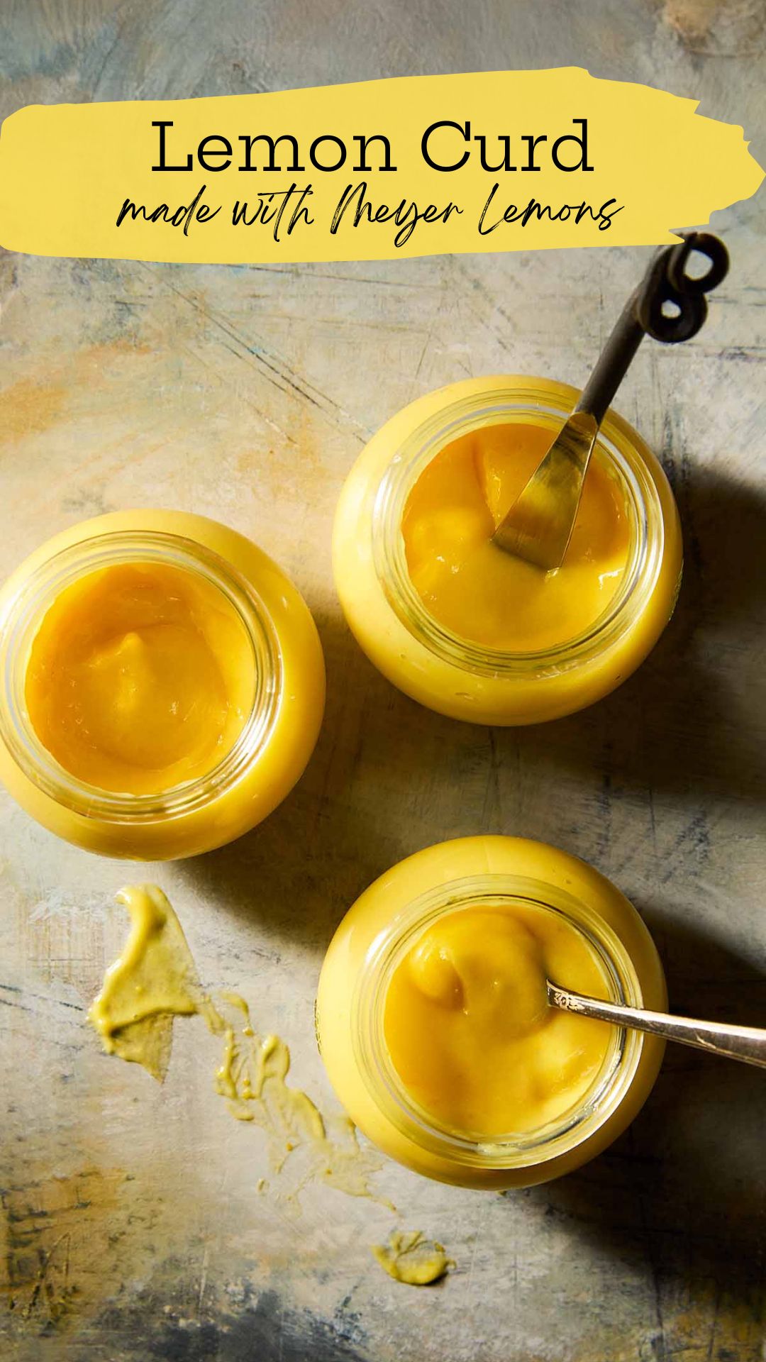 Three jars of homemade Meyer lemon curd, two with spoons in them.