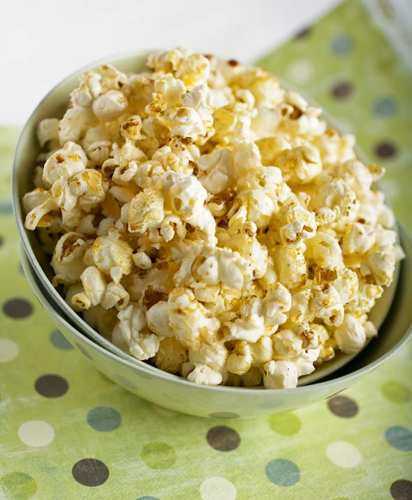 Old-fashioned kettle corn in a bowl, sitting on a green polka dot tablecloth