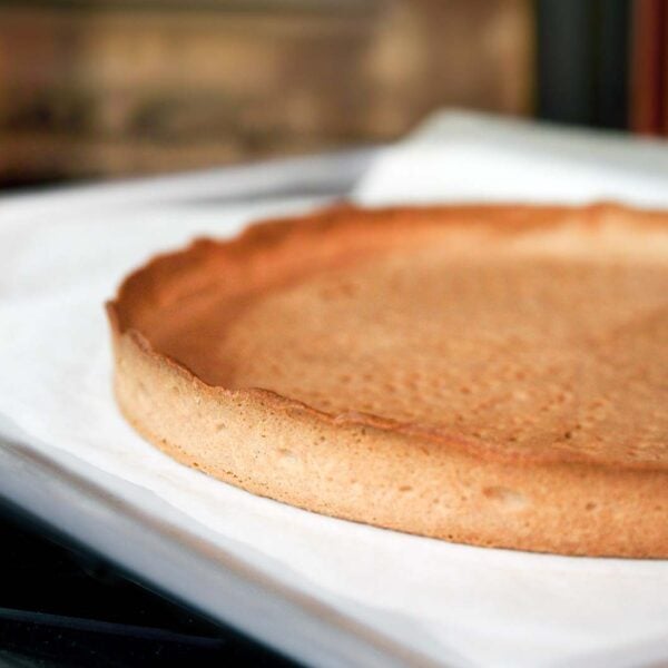 A classic pate sucree part shell cooling on a sheet pan.
