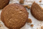 Three Parkins cookies--golden brown British biscuits flecked with oatmeal on white wood