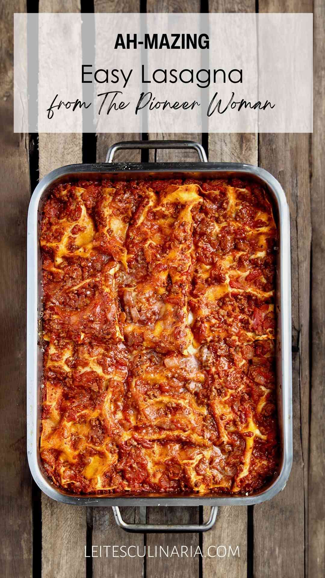 A metal baking dish filled with the Pioneer Woman's favorite lasagna on a wooden table.