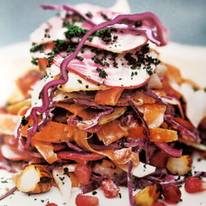 A pile of autumn coleslaw with apples, hazelnuts, red cabbage, beets, and pomegranate seeds