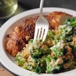 A square close-up of our creamy broccoli casserole recipe, showing a silver fork lifting a perfect bite of tender green broccoli, rich blue cheese sauce, and a shatteringly crisp breadcrumb topping.
