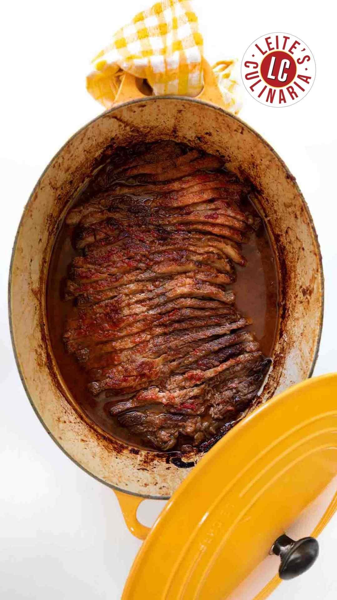 A yellow Le Creuset pot with Nach Waxman's sliced beef brisket inside.